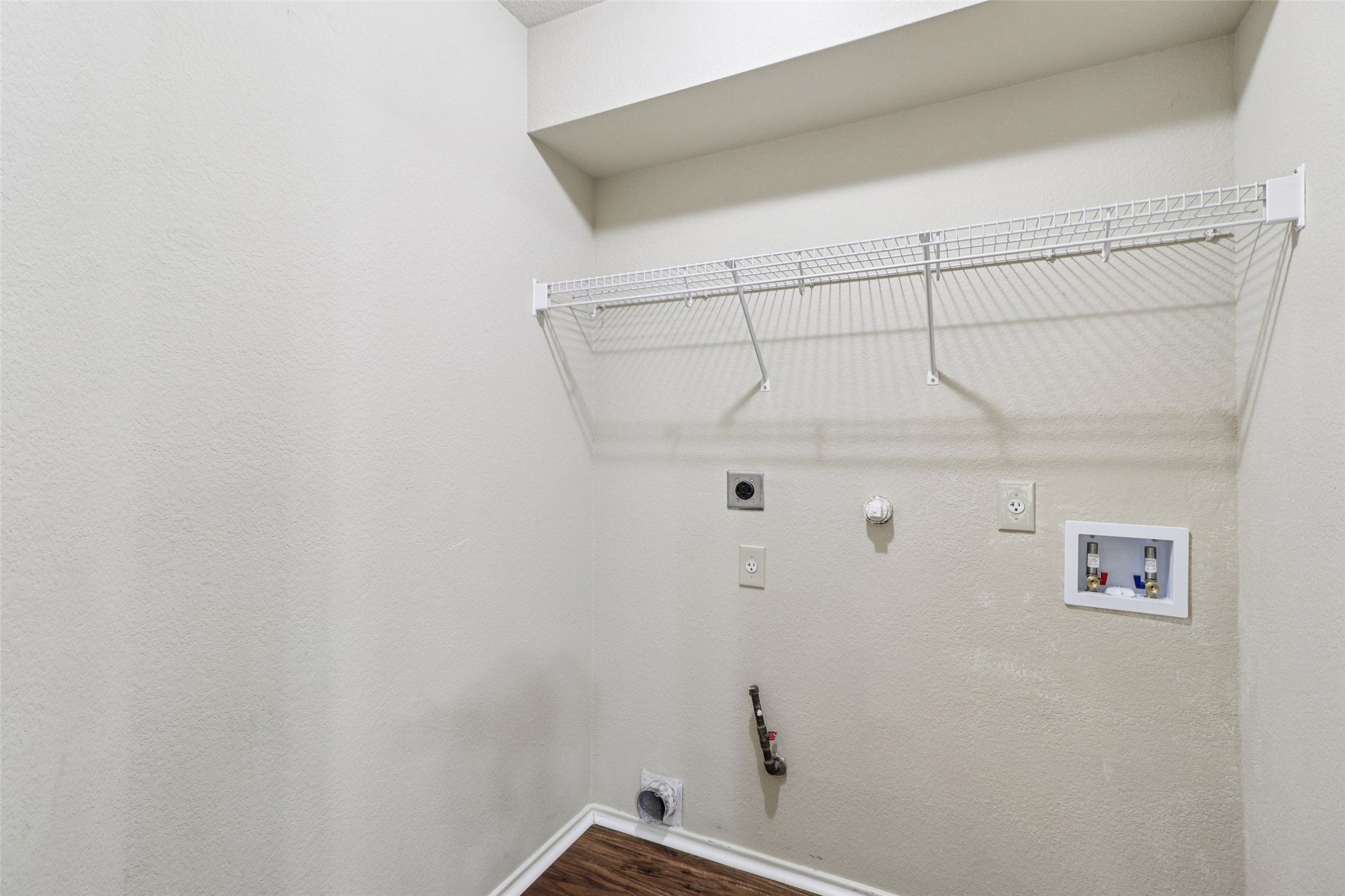 700 Scheel Road Kyle, TX 78640 - Photo 35 of 39 Laundry area featuring a wire shelf, wall outlets, and plumbing hookups