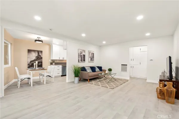 a living room with furniture a flat screen tv and a table