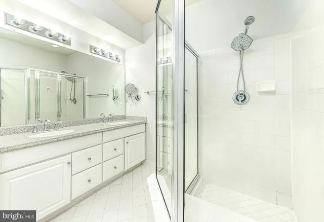a bathroom with a granite countertop sink a mirror and a shower