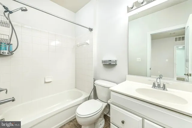 a bathroom with a sink a toilet a mirror a bathtub and shower