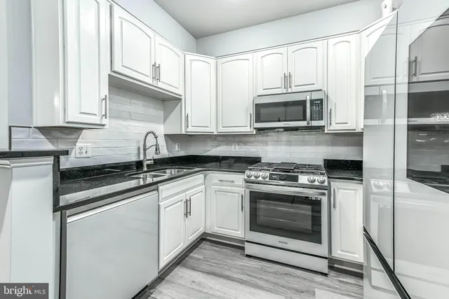 a kitchen with stainless steel appliances granite countertop a stove and a microwave