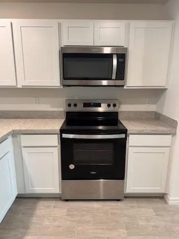 a kitchen with stainless steel appliances granite countertop a stove microwave and sink