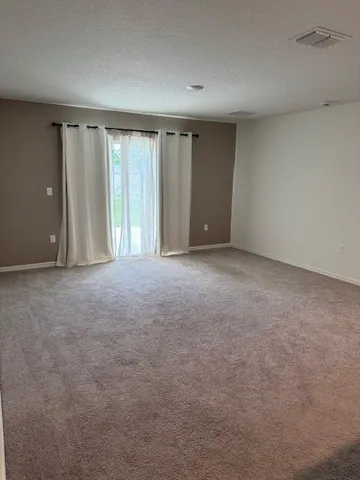 a view of an empty room with windows and closet