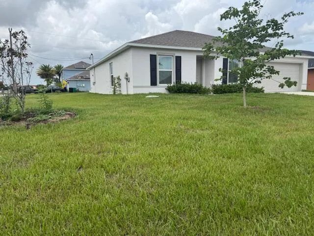 a big white house with a big yard and large trees