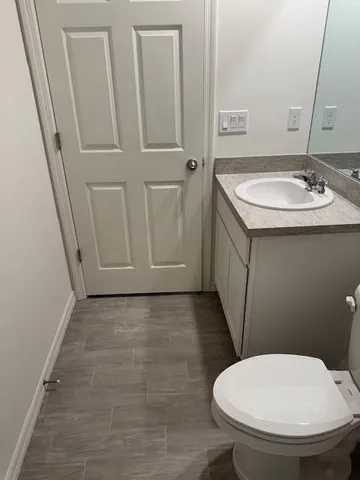 a bathroom with a sink a toilet and a mirror