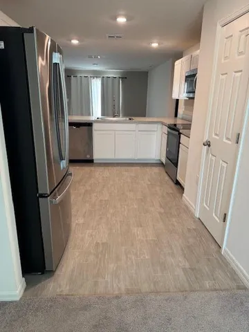 a view of kitchen with refrigerator stove and wooden floor