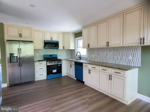 a kitchen with granite countertop white cabinets and stainless steel appliances
