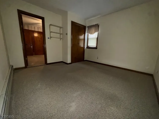 an empty room with closet and mirror