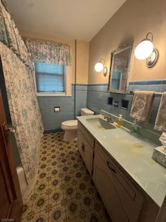 a bathroom with a sink a toilet a mirror and shower