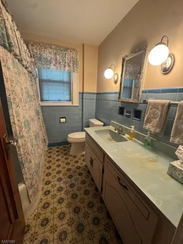 a bathroom with a sink a toilet a mirror and shower