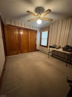 an empty room with windows and fan