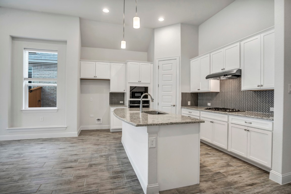 2313 Base Burner Path Leander, TX 78641 - Photo 20 of 26 a kitchen with stainless steel appliances granite countertop a stove a sink and white cabinets