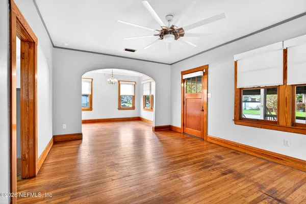 a view of an empty room with wooden floor