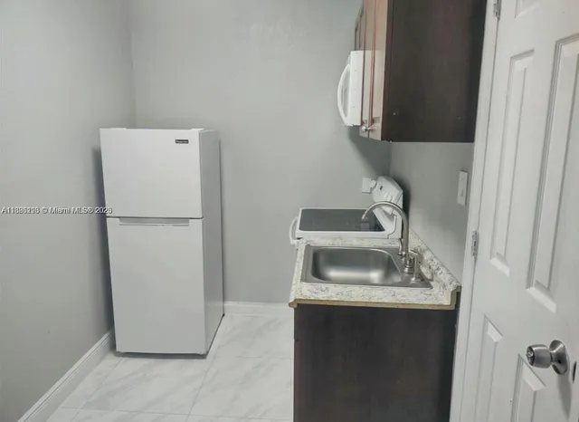 a kitchen with a sink and a refrigerator