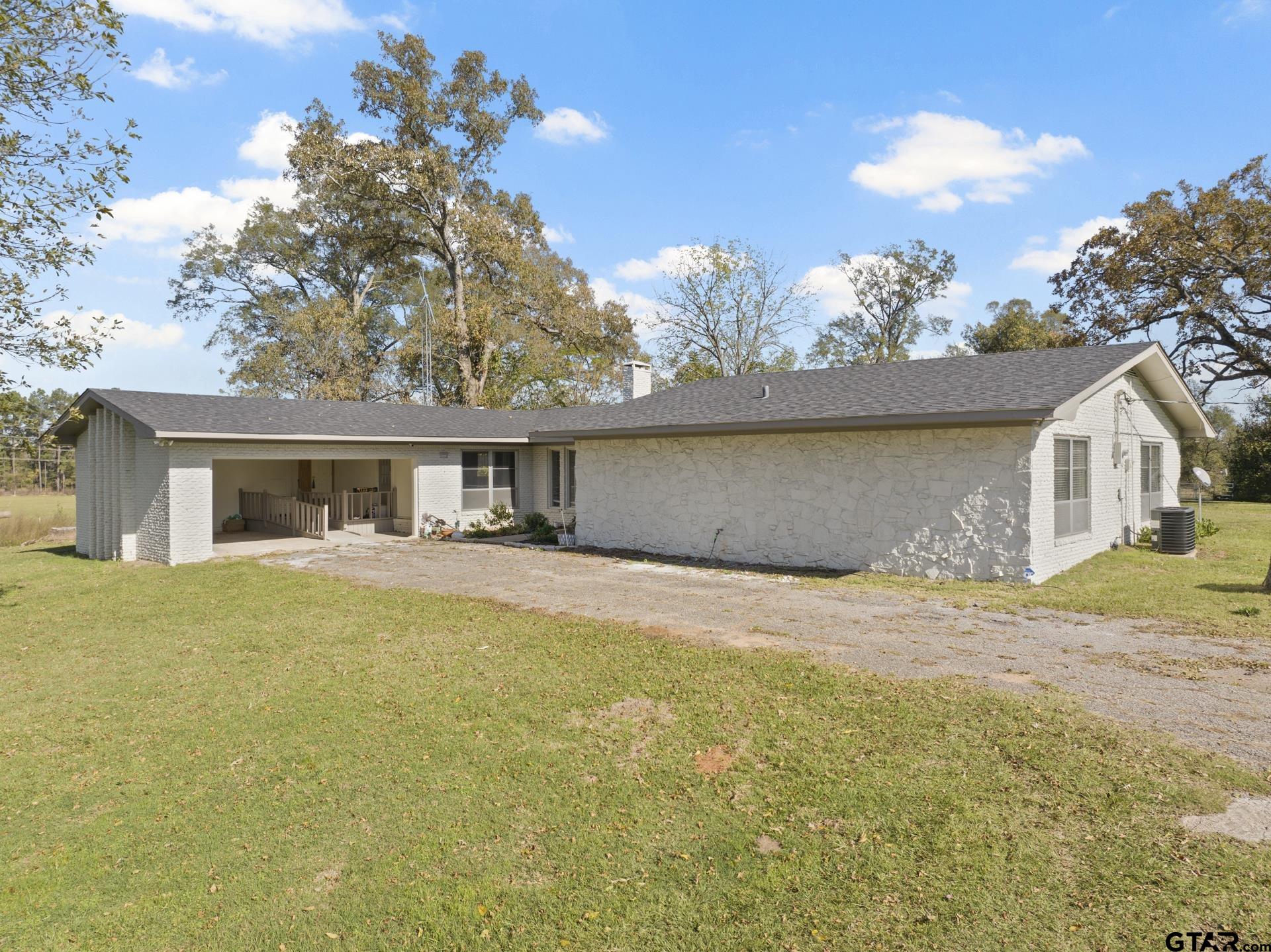 331 County Road 2106 Pittsburg, TX 75686 - Photo 2 of 32 a front view of a house with a garden