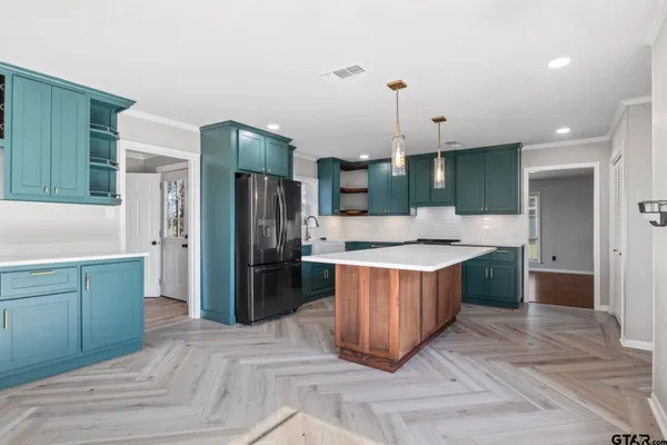 a large kitchen with a large counter top stainless steel appliances and cabinets