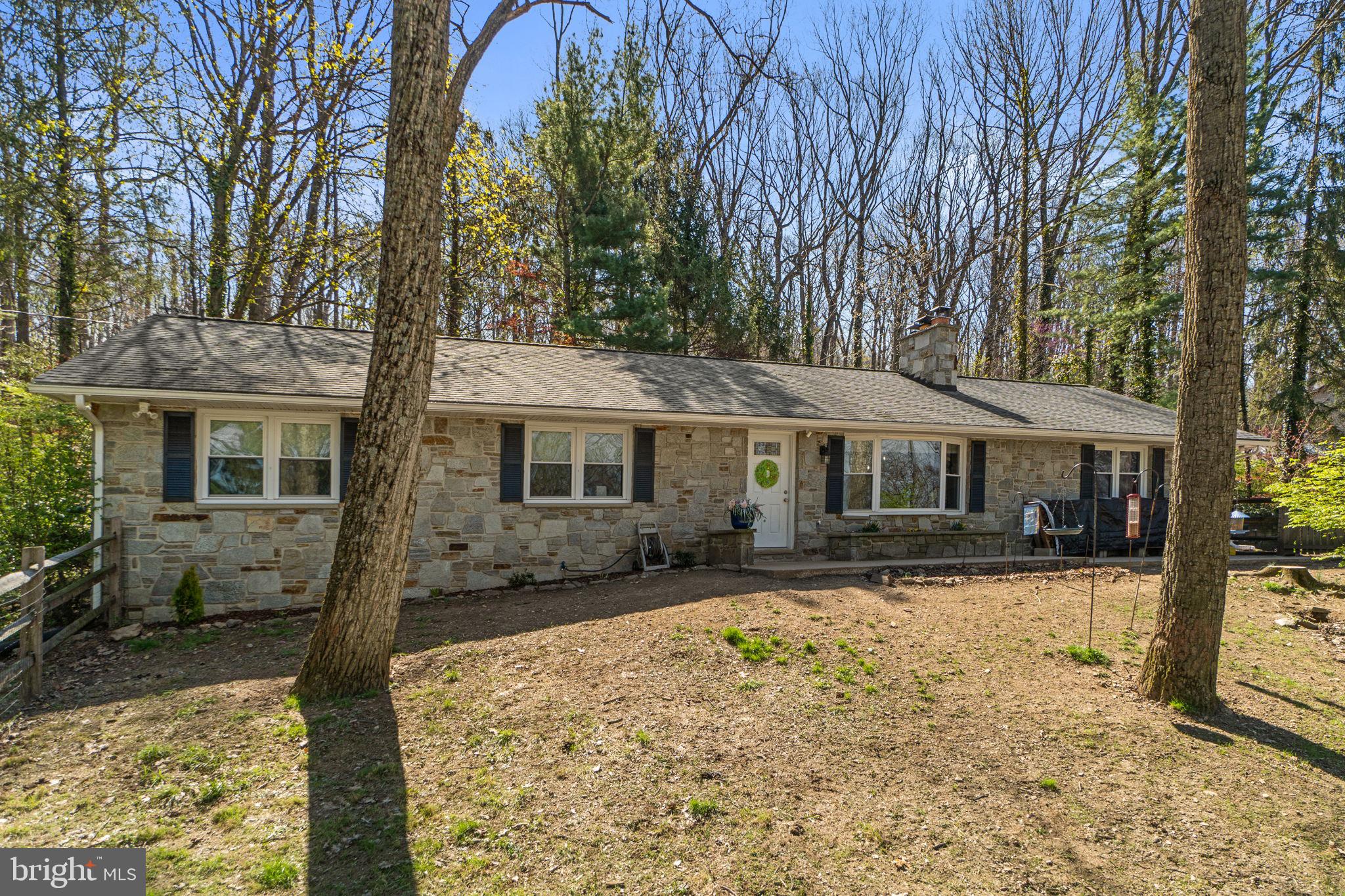 a front view of a house with yard covered with snow and trees
