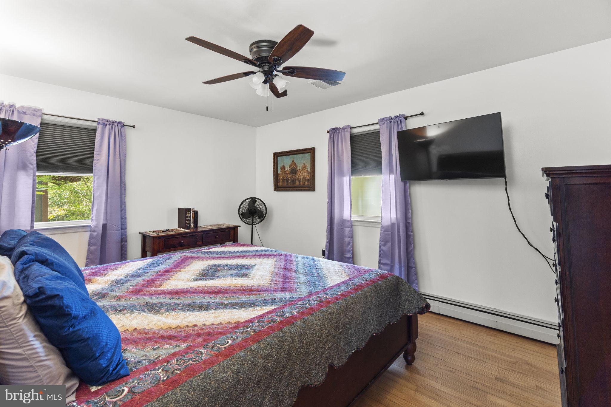2401 Albert Rill Road Hampstead, MD 21074 - Photo 18 of 38 a bedroom with a bed a window and a flat screen tv