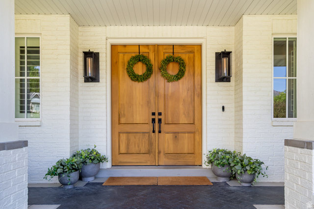 630 East Center Street Alpine, UT 84004 - Photo 10 of 115 Double wood-panel entry doors featuring black hardware, flanked by modern wall-mounted light fixtures