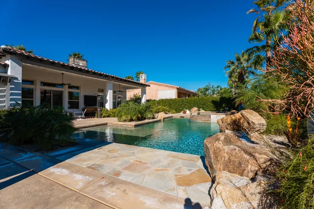 a living room with furniture a flat screen tv and a large window