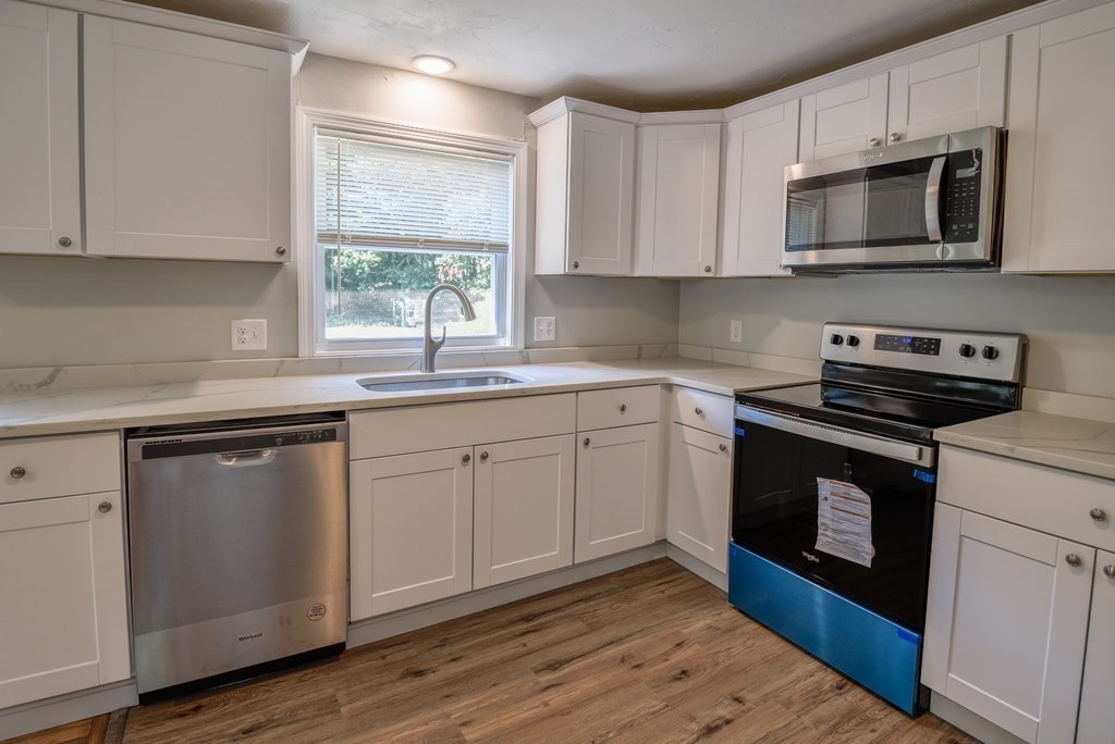 1 Ladd Road Sturbridge, MA 01566 - Photo 15 of 39 a kitchen with stainless steel appliances white cabinets granite counter tops and a wooden floors