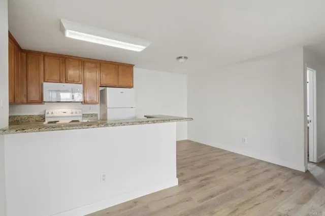 a view of kitchen with granite countertop cabinets and sink
