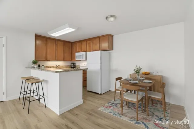 a kitchen with a refrigerator a table and chairs in it