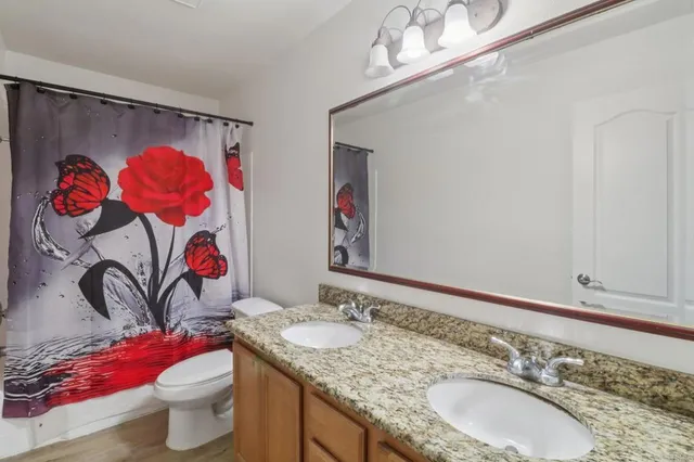 a bathroom with a granite countertop sink and a mirror