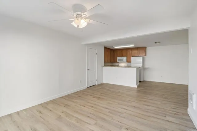 a view of a kitchen with wooden floor and a ceiling fan