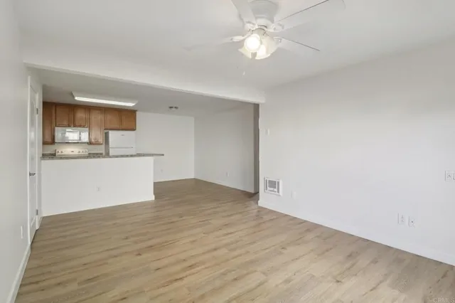a view of a kitchen with wooden floor and a ceiling fan