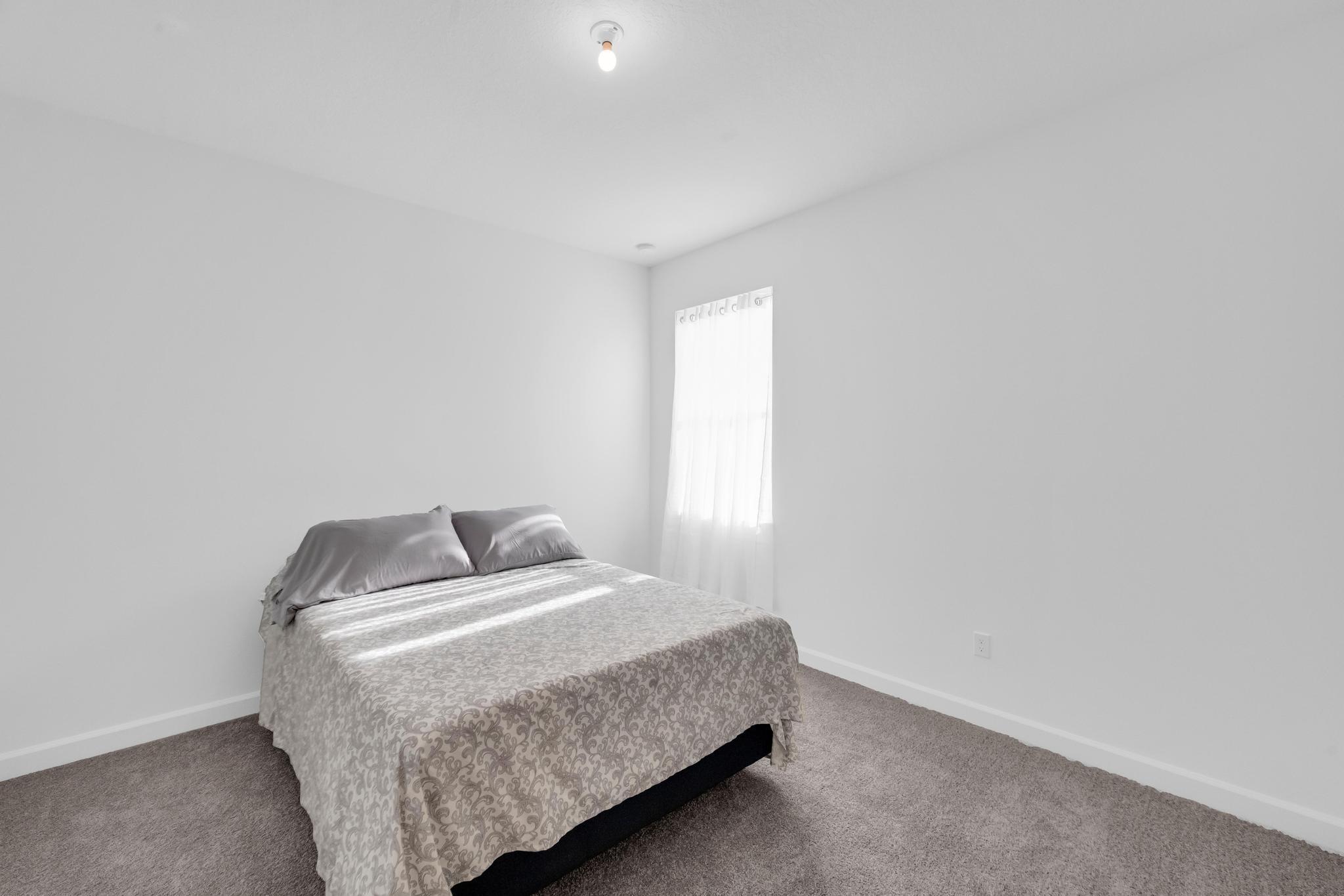 9060 Remy Lane Port St. Lucie, FL 34987 - Photo 17 of 33 a bedroom with a bed and a window