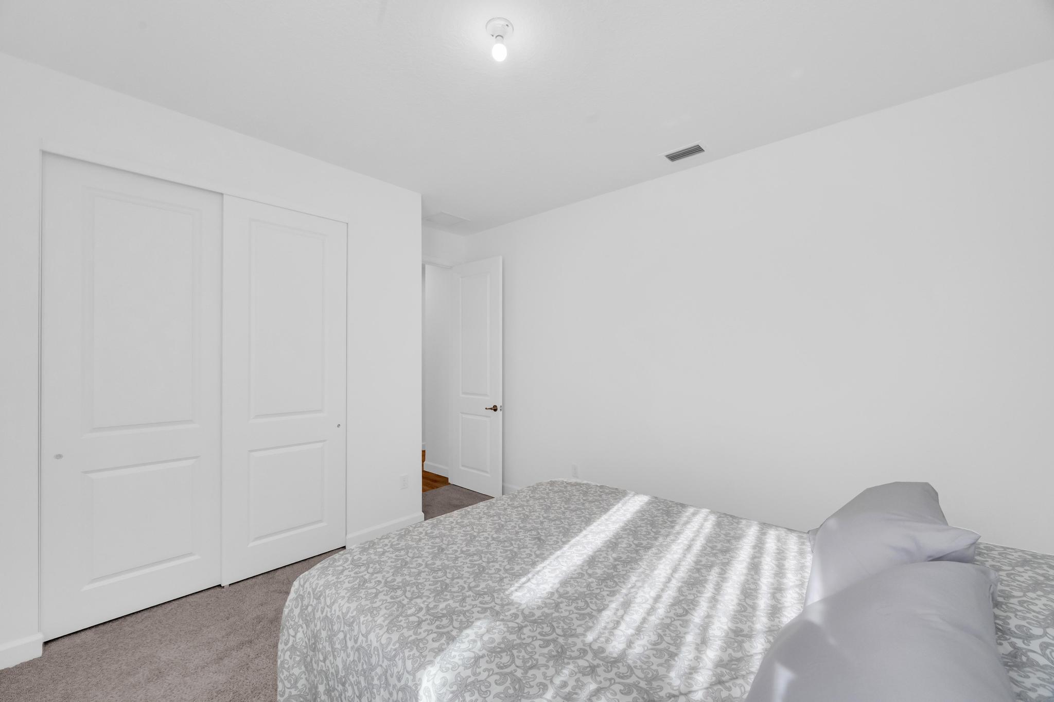 9060 Remy Lane Port St. Lucie, FL 34987 - Photo 18 of 33 a bedroom with a bed and a rug