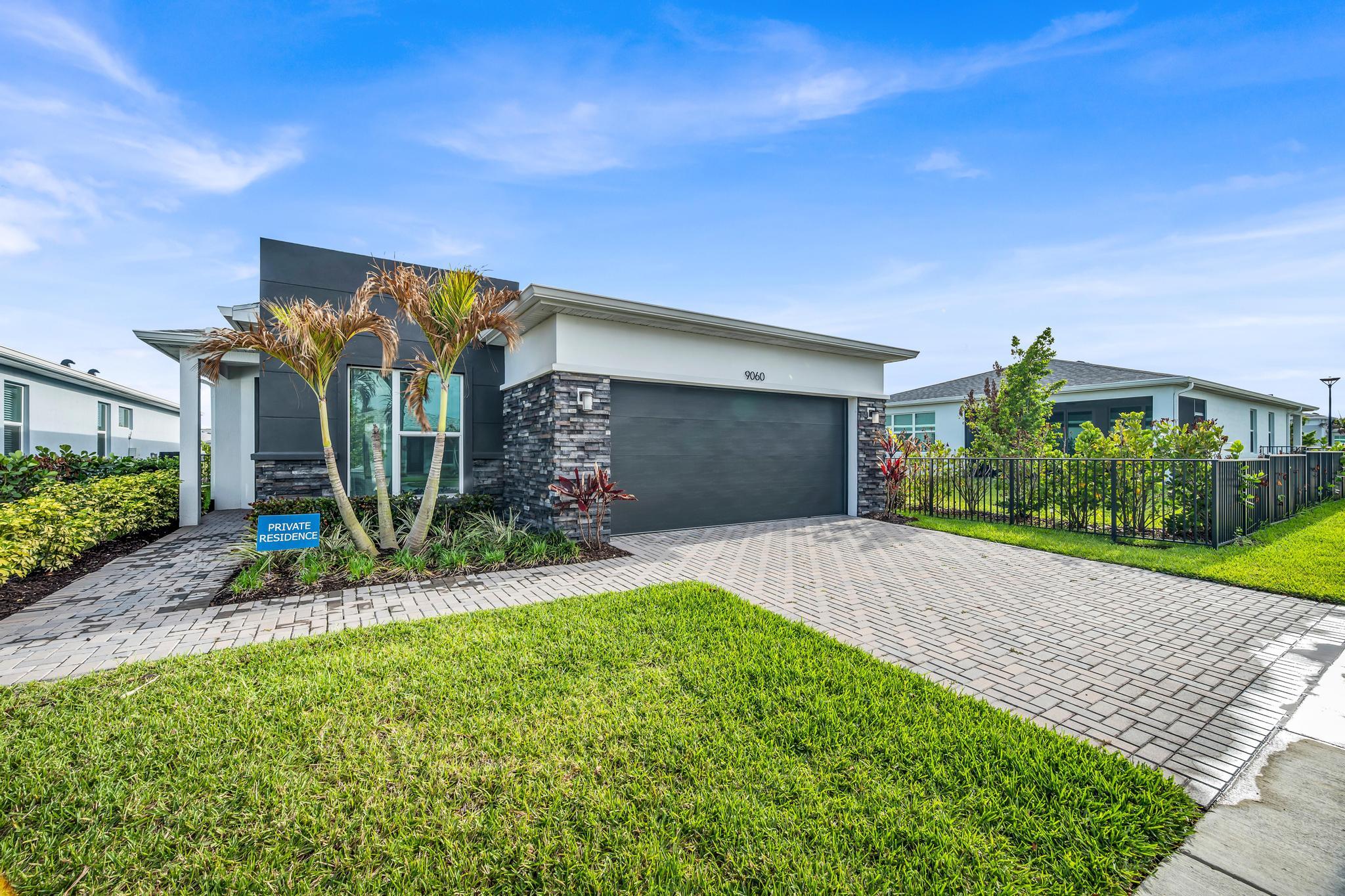 9060 Remy Lane Port St. Lucie, FL 34987 - Photo 2 of 33 a front view of a house with a yard and potted plants