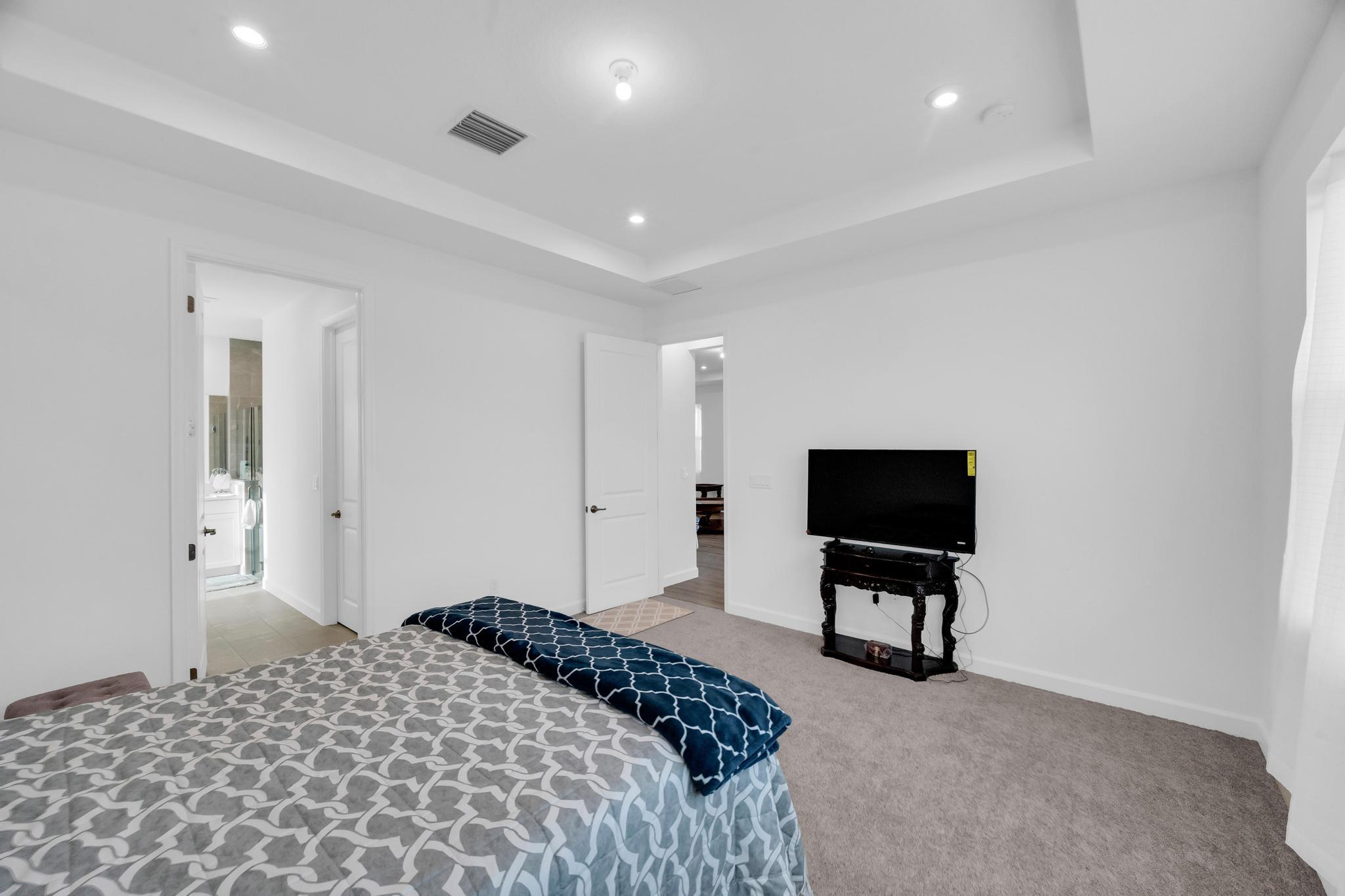 9060 Remy Lane Port St. Lucie, FL 34987 - Photo 22 of 33 a bedroom with a bed and a flat screen tv