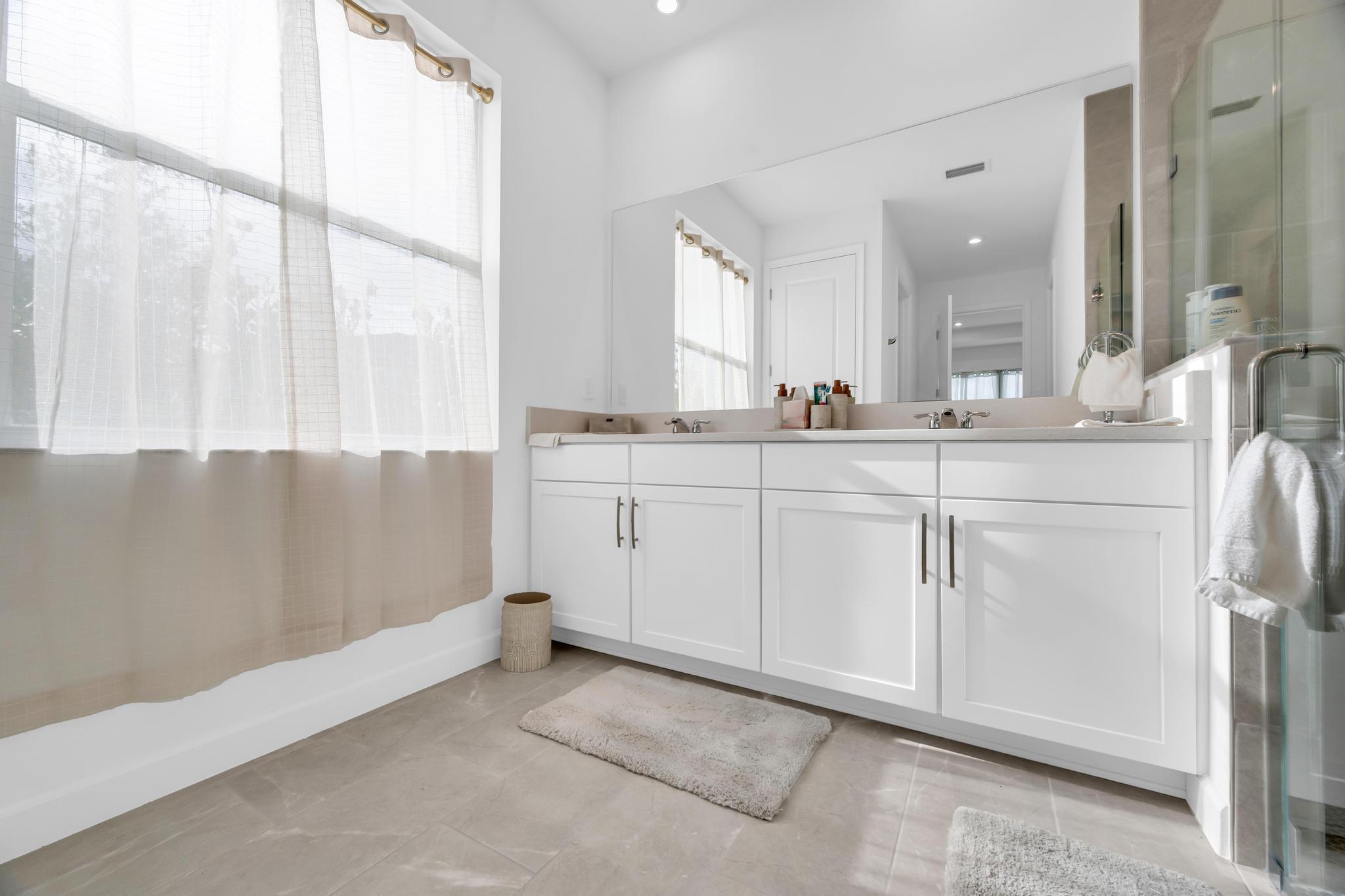 9060 Remy Lane Port St. Lucie, FL 34987 - Photo 26 of 33 a spacious bathroom with a sink and a mirror