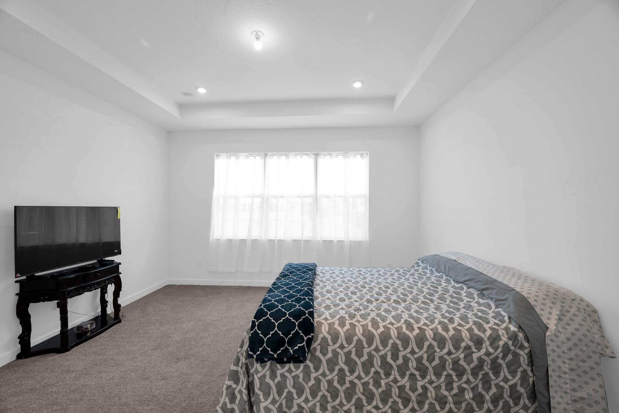 9060 Remy Lane Port St. Lucie, FL 34987 - Photo 29 of 33 a bedroom with bed and a flat tv screen on dresser