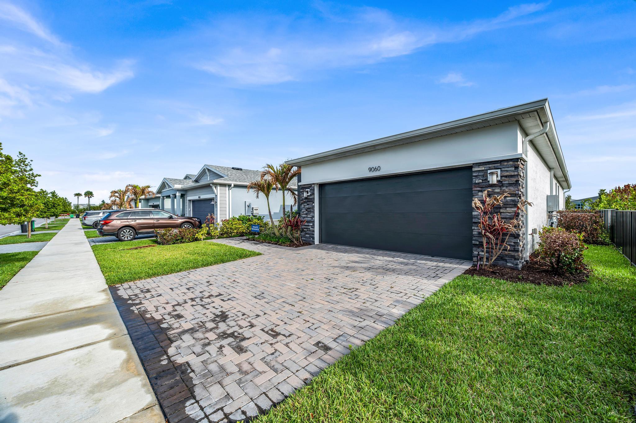 9060 Remy Lane Port St. Lucie, FL 34987 - Photo 5 of 33 a front view of a house with a yard and garage