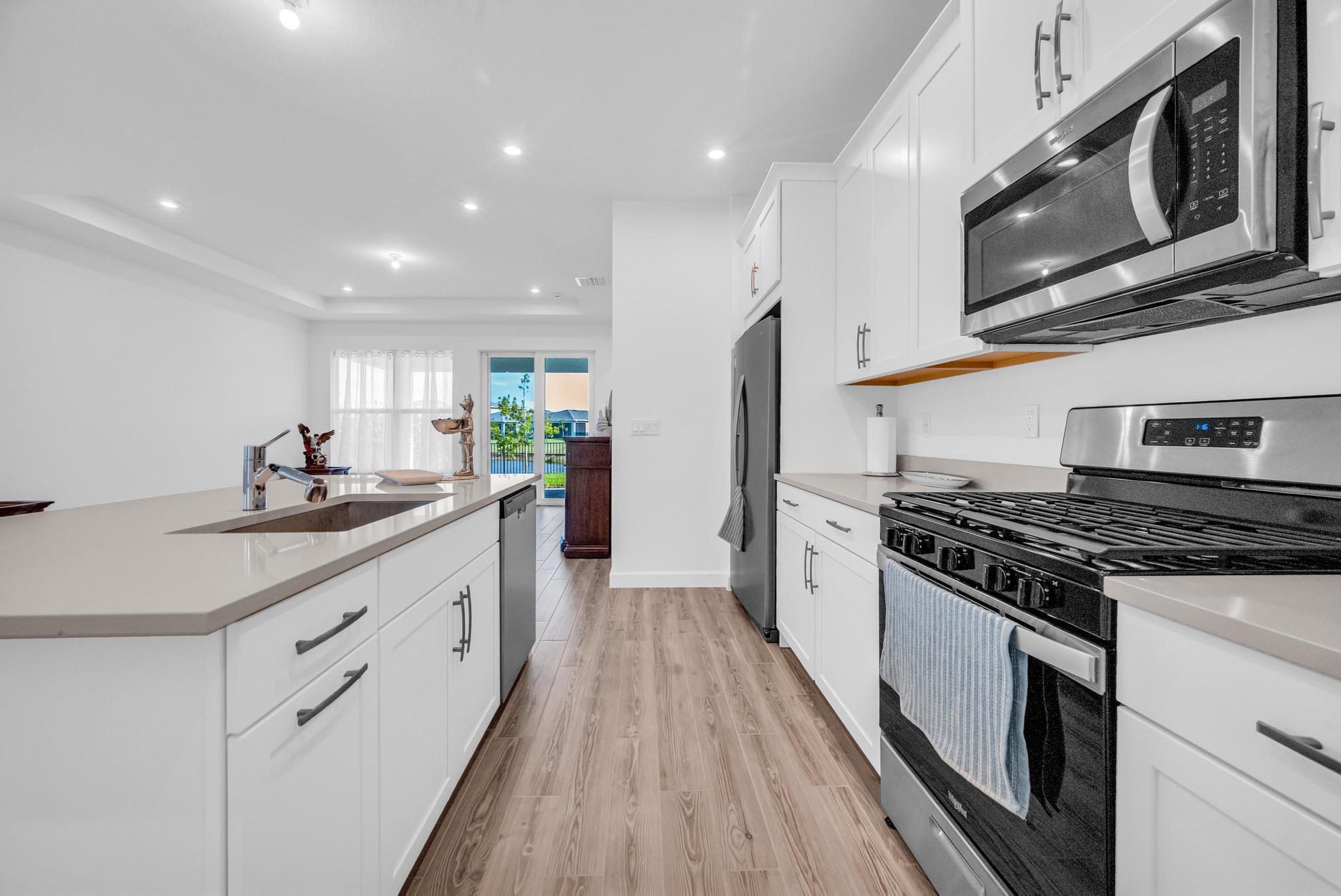 9060 Remy Lane Port St. Lucie, FL 34987 - Photo 9 of 33 a kitchen with stainless steel appliances granite countertop a stove a sink dishwasher and a refrigerator