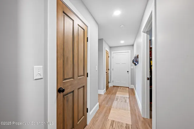 a view of a hallway with wooden floor and staircase