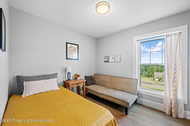 a bedroom with two beds and a potted plant
