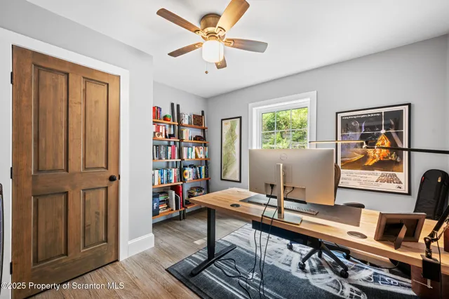 a living room with furniture a bookshelf and a window
