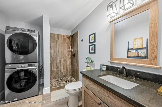 a bathroom with a granite countertop toilet a sink and a mirror