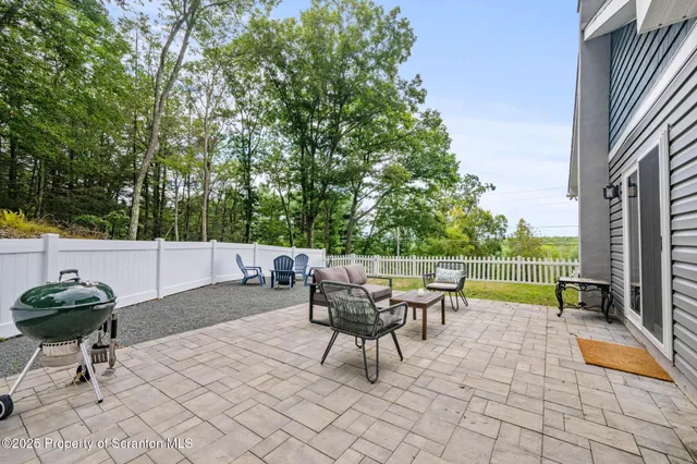 a roof deck with table and chairs and potted plants