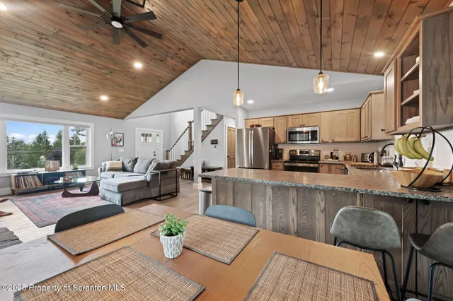 a living room with furniture kitchen view and a large window