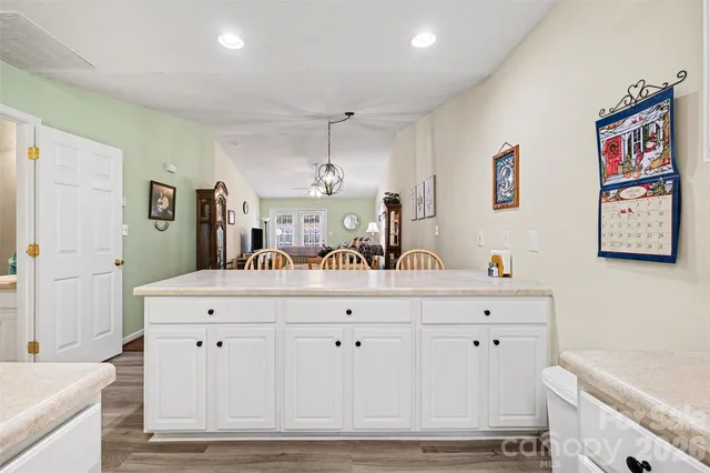 a kitchen with white cabinets stainless steel appliances and dining table