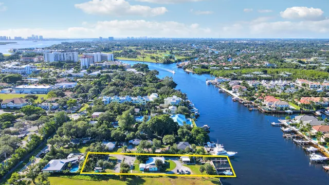 an aerial view of residential houses with outdoor space and lake view