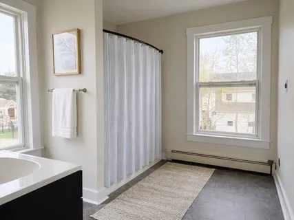a view of a room that has a window and a dresser in it