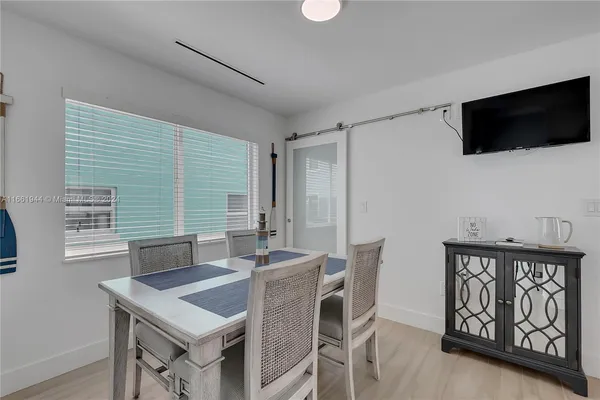 a view of a dining room with furniture and a flat screen tv
