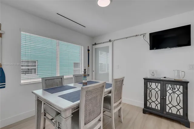 a view of a dining room with furniture and a flat screen tv
