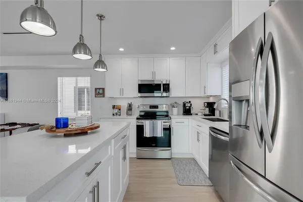 a kitchen with stainless steel appliances a refrigerator sink and microwave